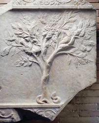 Basrelief af et træ med fugle i grenene og en slange ved foden
